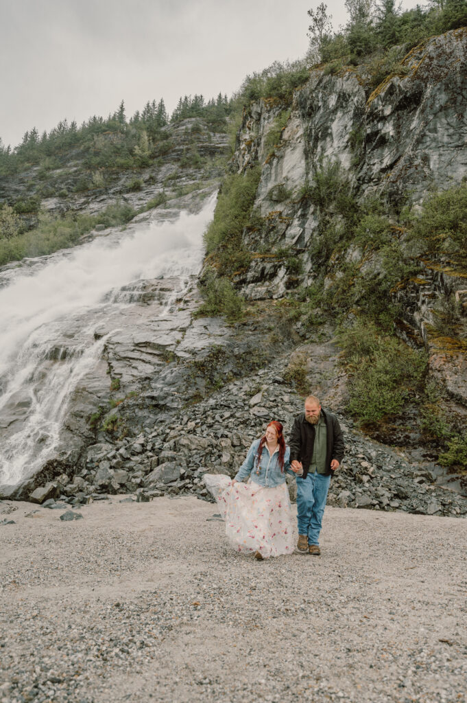 Couple walking and hold their hands by the Nugget Falls