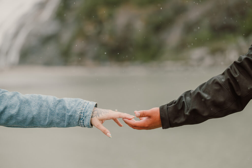 Hands holding with Nugget Falls in the background