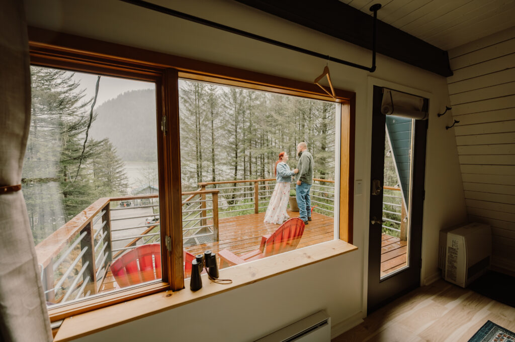 Couple stand on the deck outside of the cabin