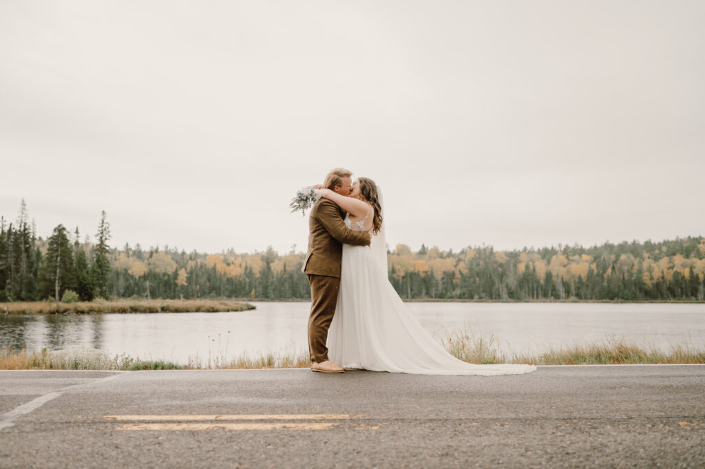 couple kissing on side of the road.