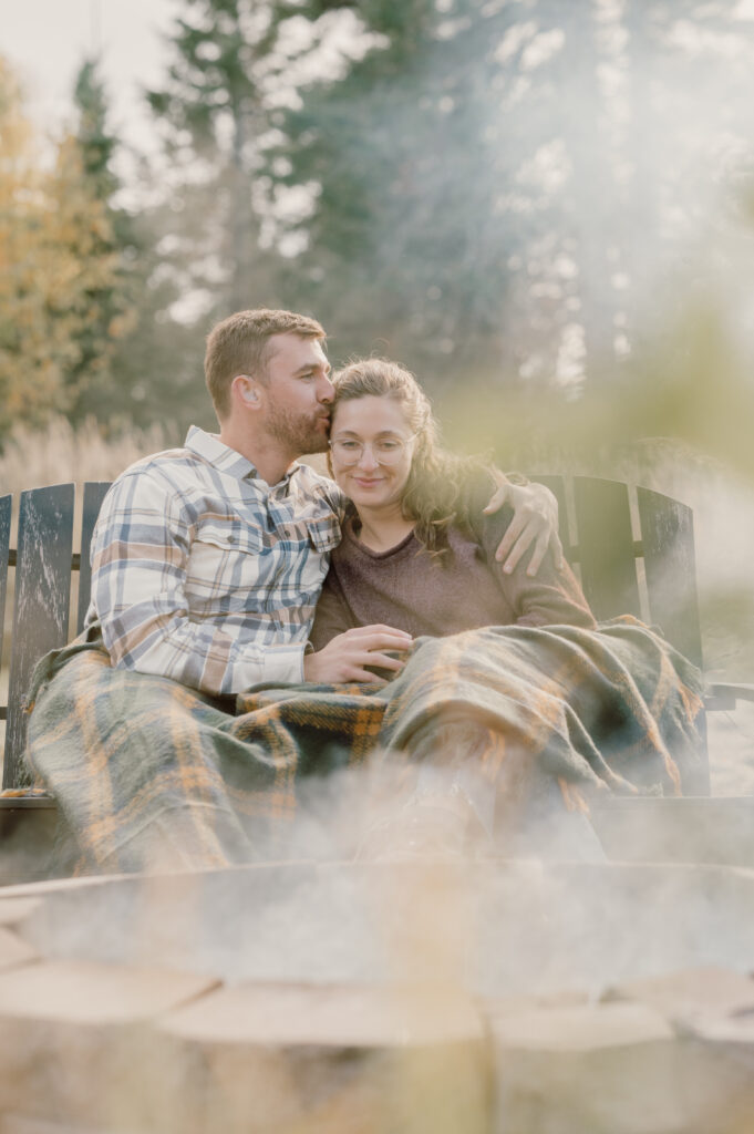 the couple were wrapped in a blanket and cuddled by the campfire