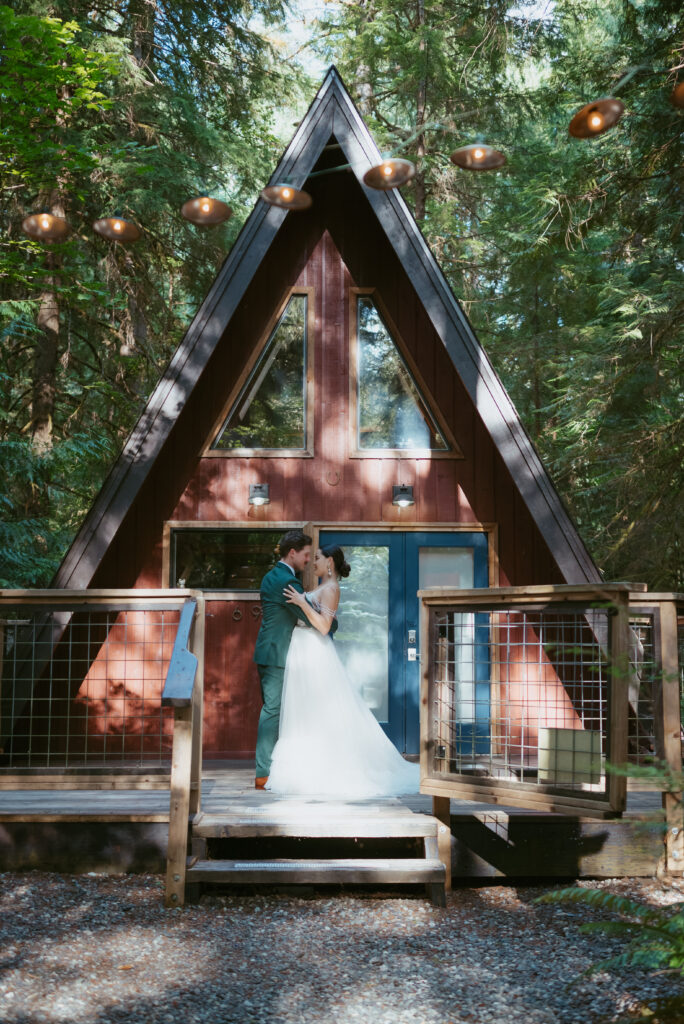 couple hugging front of a-frame airbnb