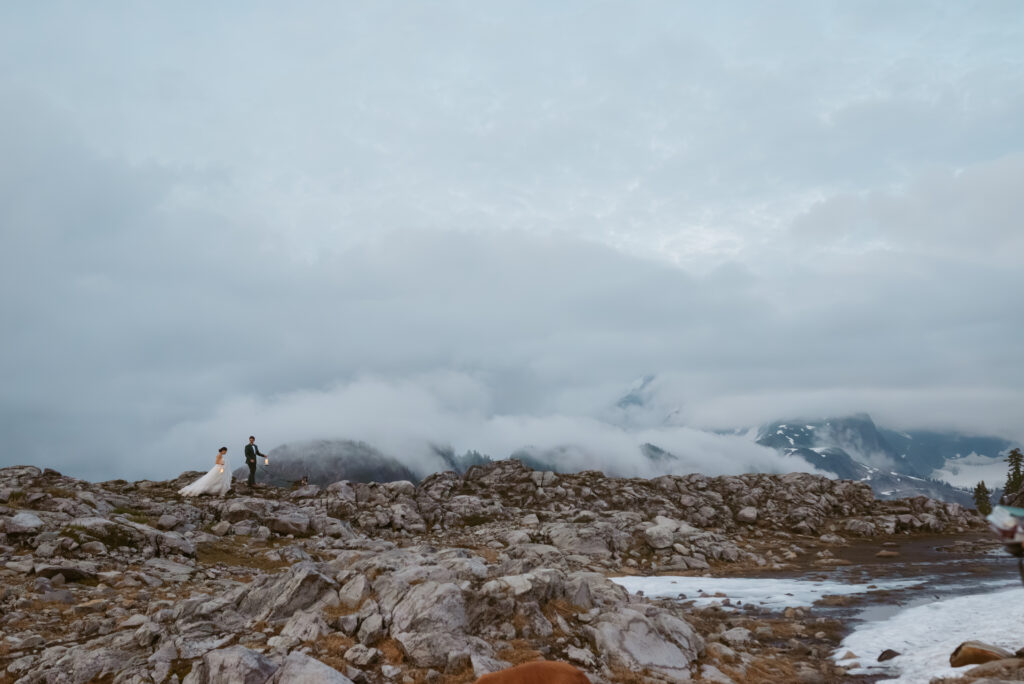 couple walking on the rocks by Mt. Baker