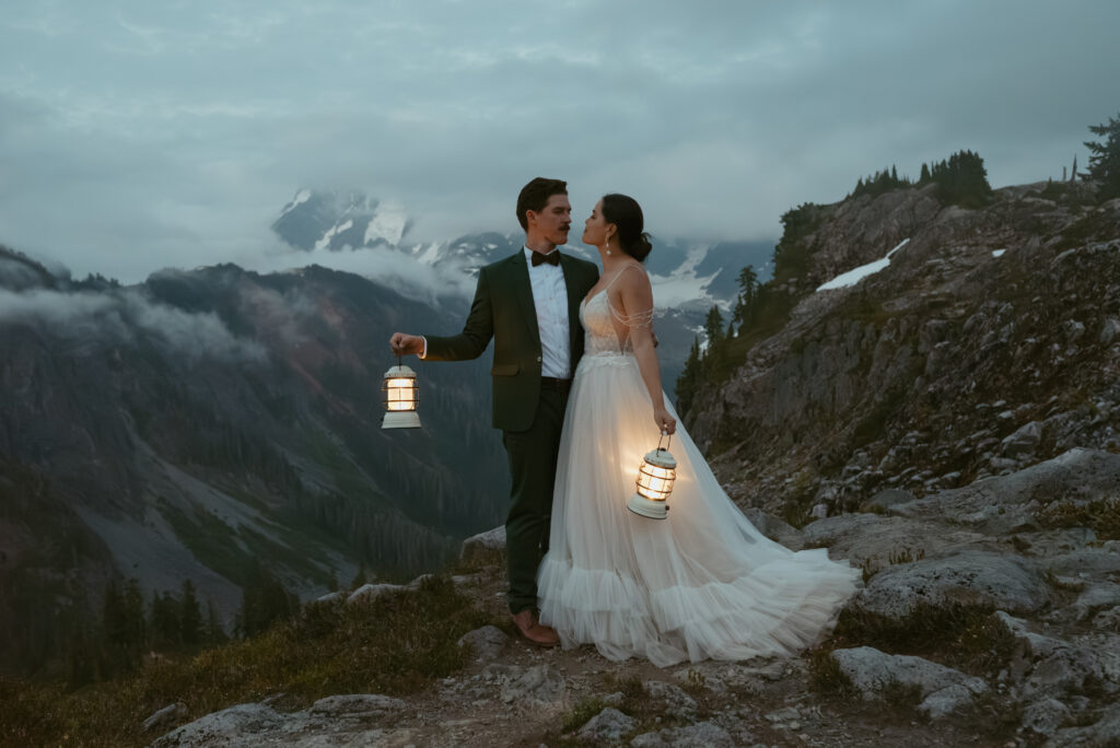 couple hold lanterns and look at each other