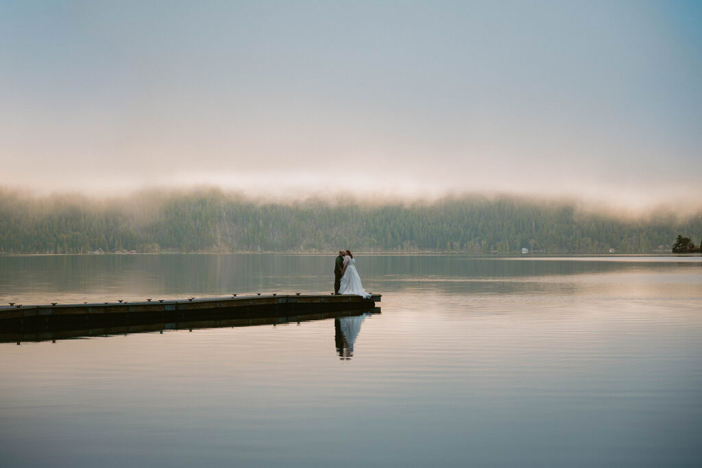 Foggy and sunrise at Lake Crescent with elopement couple kissing on the dock